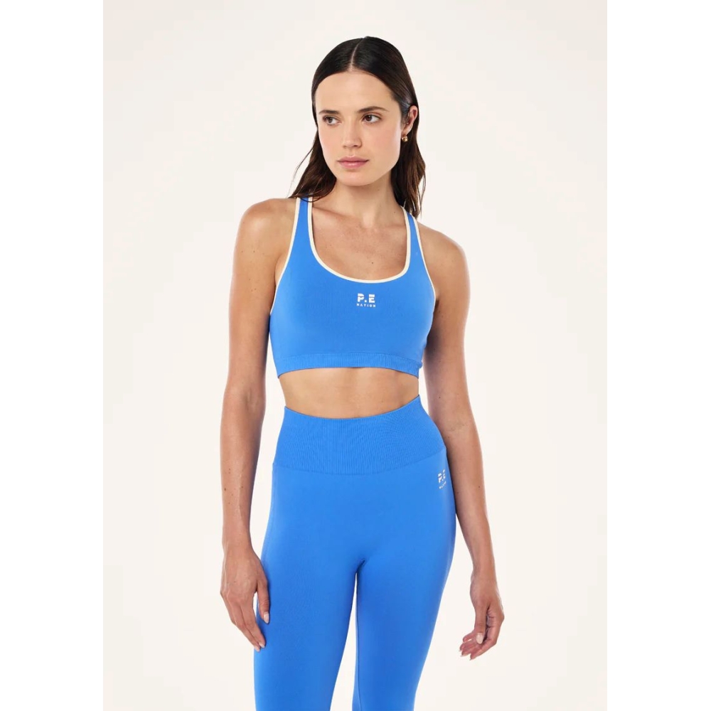 P.E Nation "Restore Seamless Sports Bra" besiulė mėlynos spalvos sportinė liemenėlė. Sportinės liemenėlės